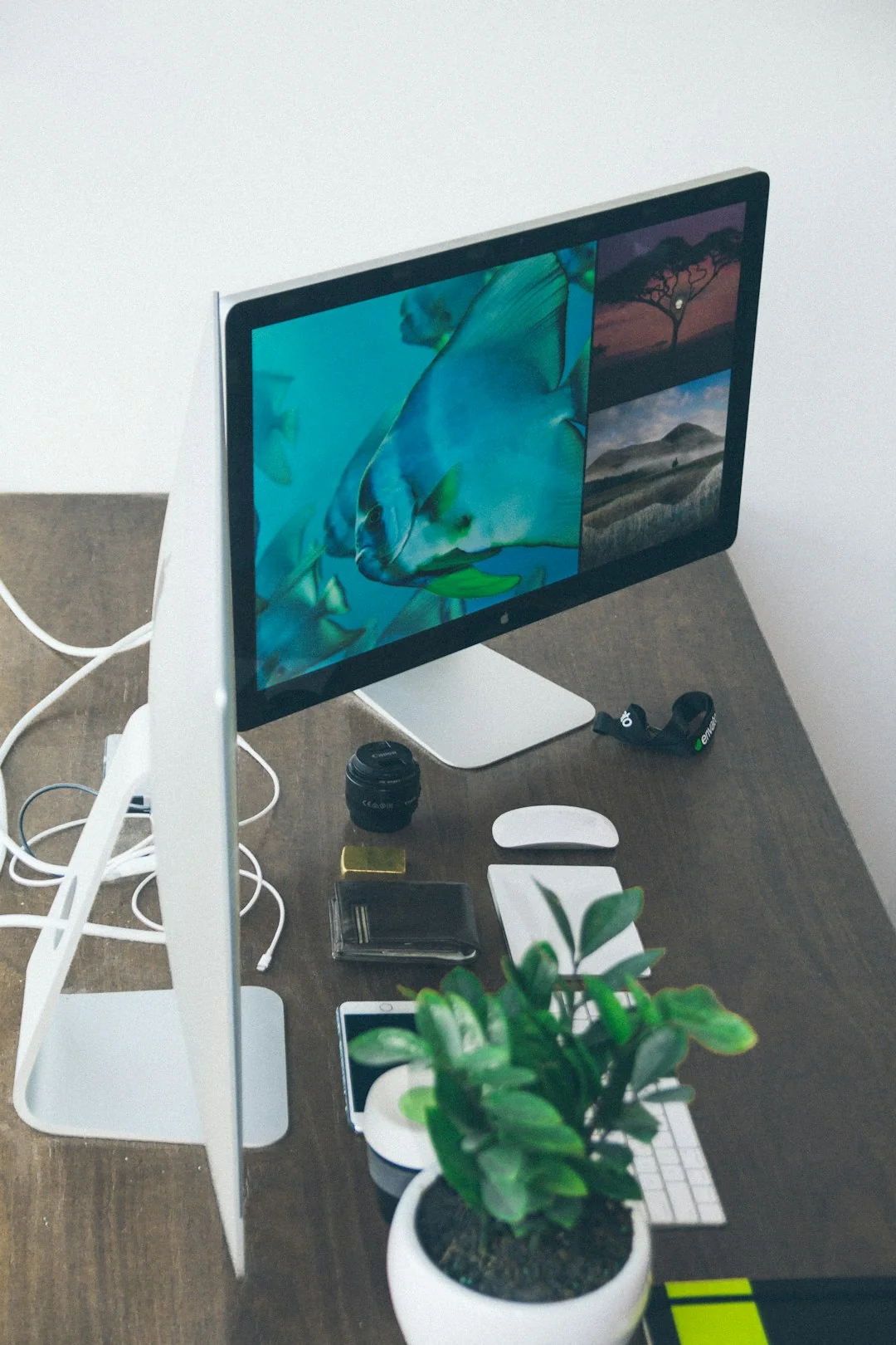 Flat lay image featuring a laptop, open magazine, credit cards, and eyeglasses on a marble table.